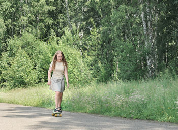 Teenager girl practicing skateboarding in a park. caucasian curly teen girl with long blond hair. 