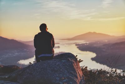 Rear view of a man sitting on mountain