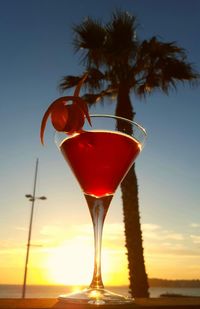 Close-up of cosmopolitan at beach during sunset