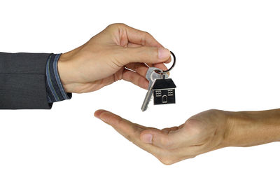 Close-up of man holding hands over white background