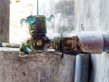 Close-up of old faucet against wall