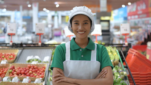 Portrait of smiling young woman standing at store