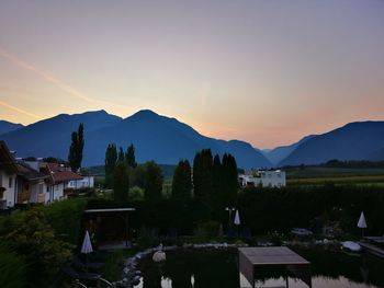 Scenic view of townscape by mountains against sky