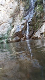 Scenic view of waterfall against sky
