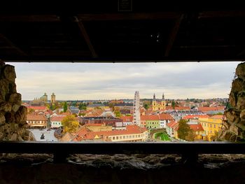 Bridge over river amidst buildings in city against sky