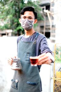 Full length of young man drinking glass