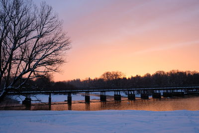 Scenic view of lake against orange sky during winter