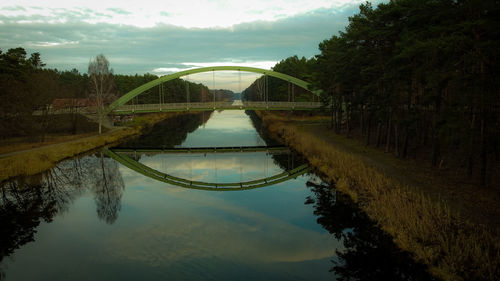 Arch bridge over river against sky