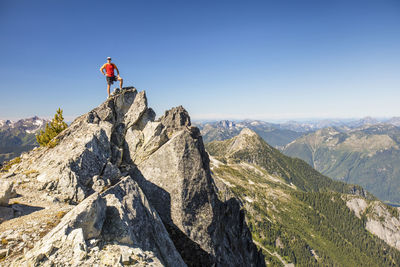 Backpacker stands on summit of mountain after a long day of hiking