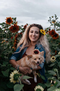 Portrait of woman with dog against plants