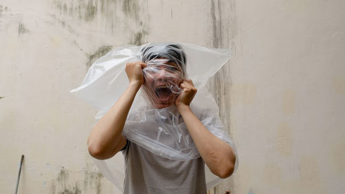 Young man with a black plastic bag on his head. suffocate. person