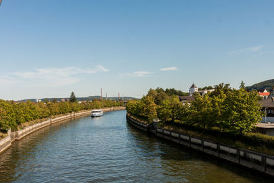 Bridge over river amidst buildings in city against sky