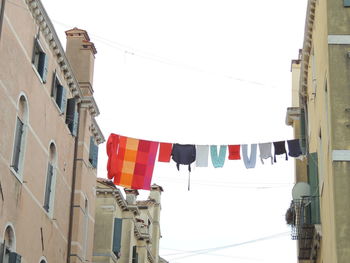 Low angle view of flags hanging against sky