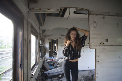 Portrait of young woman standing in abandoned building