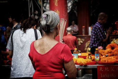 Rear view of people at market stall in city