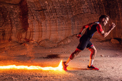 Digital composite image of athlete running in front of fire
