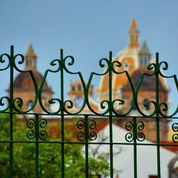 Close-up of metal gate against cathedral in city