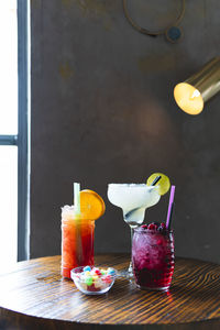 Glasses of various cocktails on table at bar