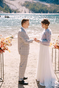 Couple exchanging rings at riverbank