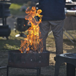 Low section of man standing on barbecue grill