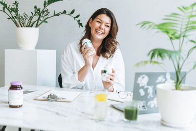 Nutritionist in white working at laptop in modern office. doctor communicates with patient online