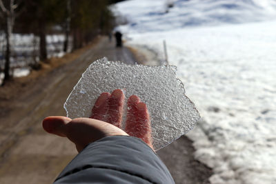 Close-up of hand holding ice at beach