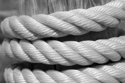Detail shot of ropes coiled around wooden post