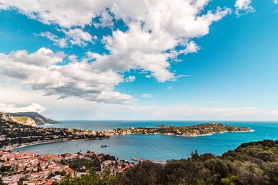 Panoramic view of city by sea against blue sky