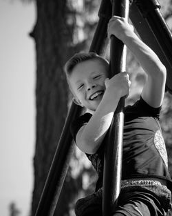 Full length of cute boy holding slide in playground