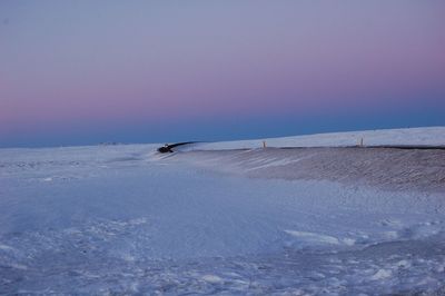 Scenic view of  icelandic  snow fields and road against  pink sky during winter