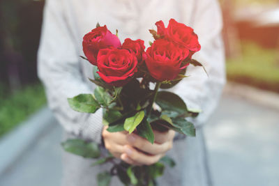 Close-up of hand holding rose bouquet