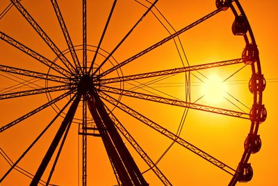 Low angle view of ferris wheel against sky during sunset