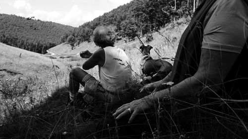 Senior couple sitting with dog on mountain