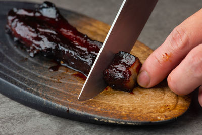 Close-up of hand holding bread on table