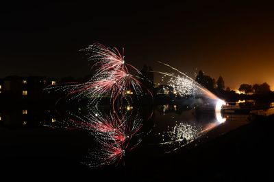 Firework display over river at night