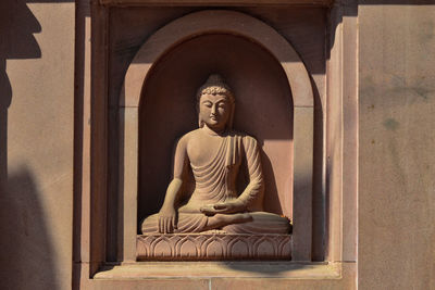 Statue of buddha against building