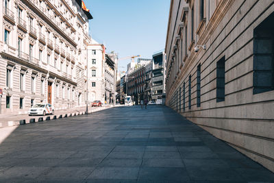 Footpath amidst buildings in city