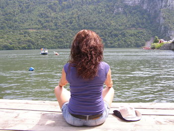 Rear view of woman looking at lake against mountain