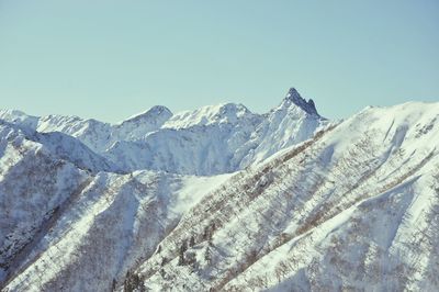 Scenic view of snowcapped mountains against clear blue sky