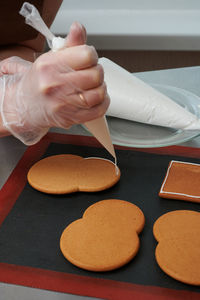 Cropped hand of woman preparing food on table