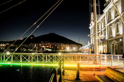 Illuminated bridge over river at night