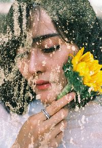 Close-up portrait of woman with pink flower