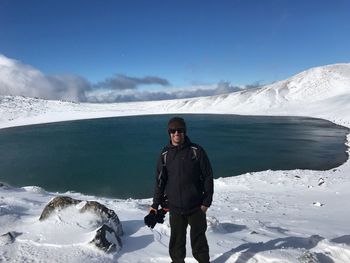 Full length of woman on snowcapped mountain against sky