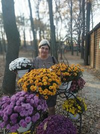 Woman standing by purple flowering plants