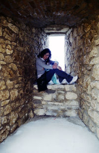 Side view of young man against wall in winter