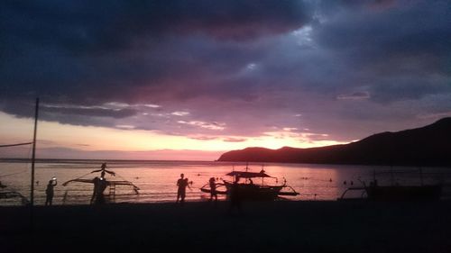 Scenic view of sea against cloudy sky at sunset