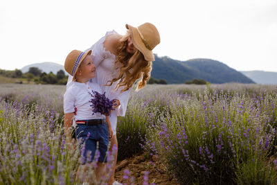 Rear view of woman with flowers on field