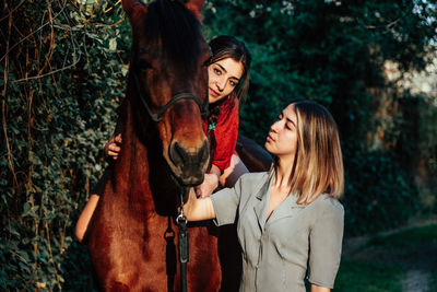 Portrait of women with horse outdoors