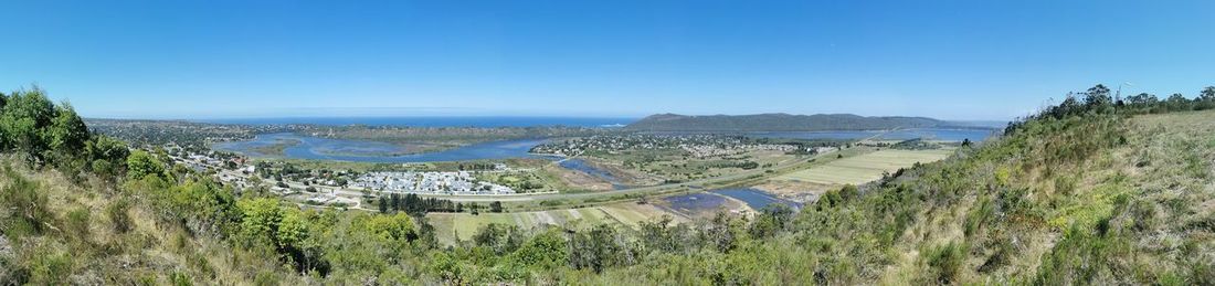 Panoramic view of landscape against clear blue sky