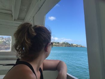 Close-up of young woman by sea against sky